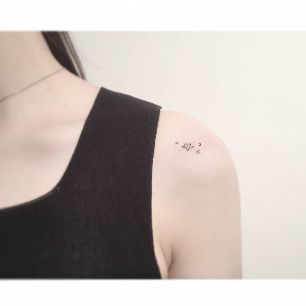 Minimalistic universe and plane tattoo located on the shoulder.