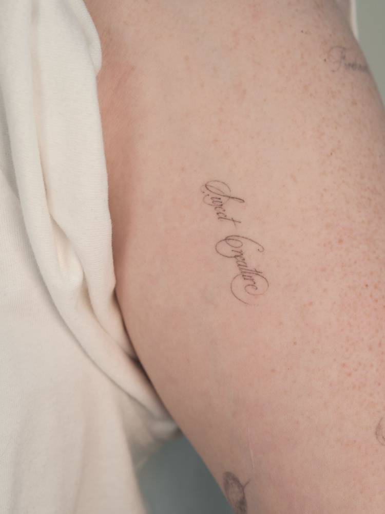 "Sweet creature" lettering tattoo located on the upper arm.