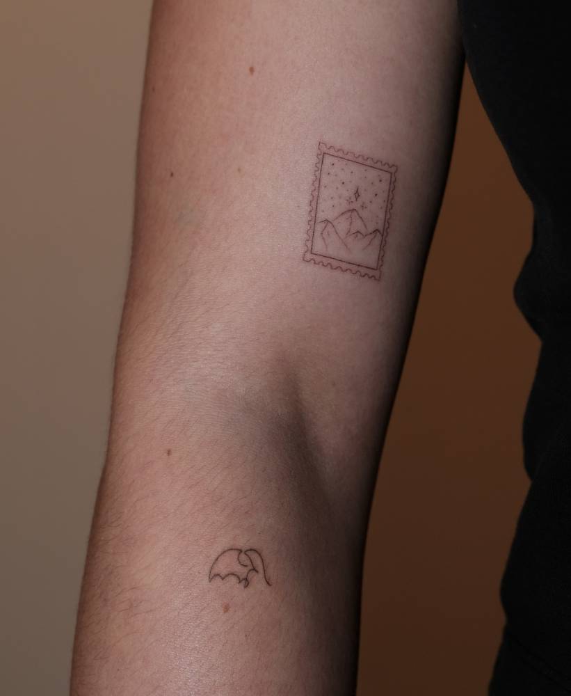 Mountain stamp and one line elephant tattoos in fine line style.