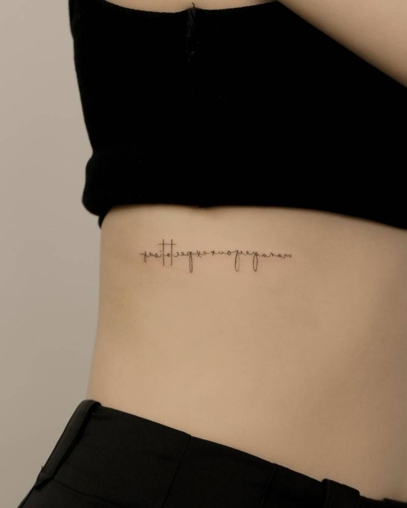 Handwritten font lettering tattoo located on the rib.