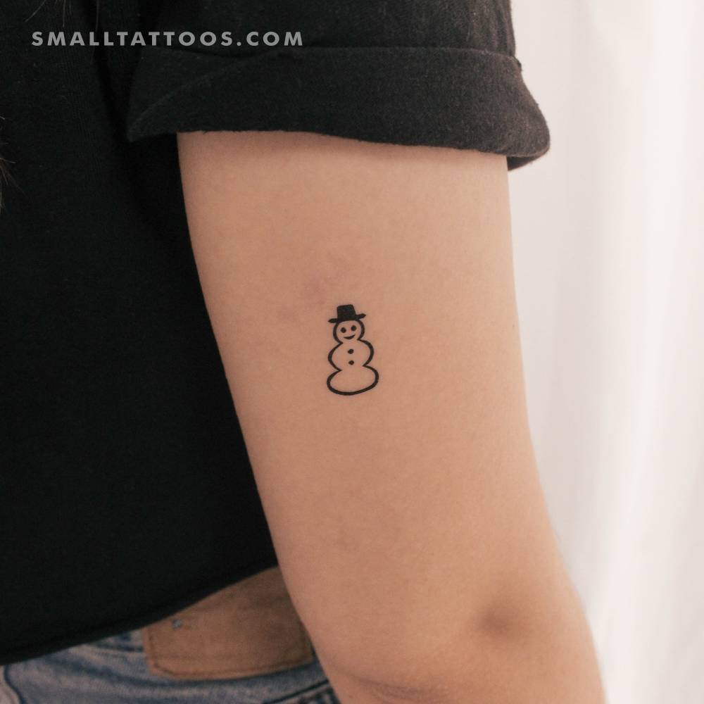 Small snowman temporary tattoo located on the tricep.