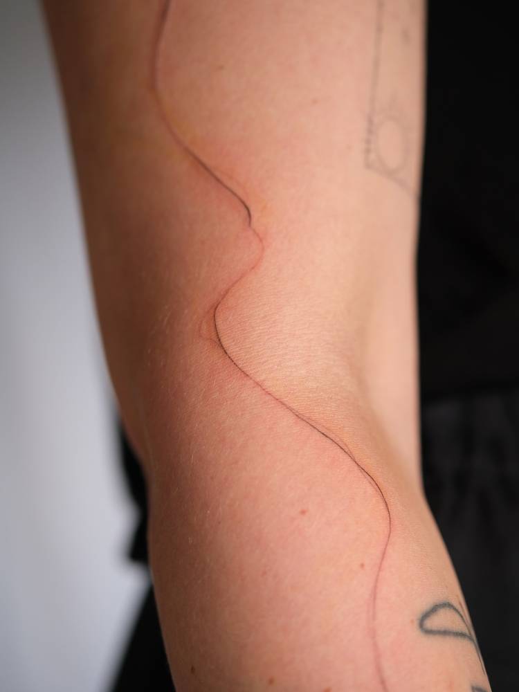 Freehand abstract line tattoo located on the arm.