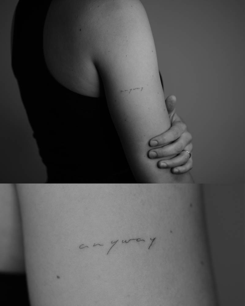 "Anyway" lettering tattoo in handwritten font located on the upper arm.