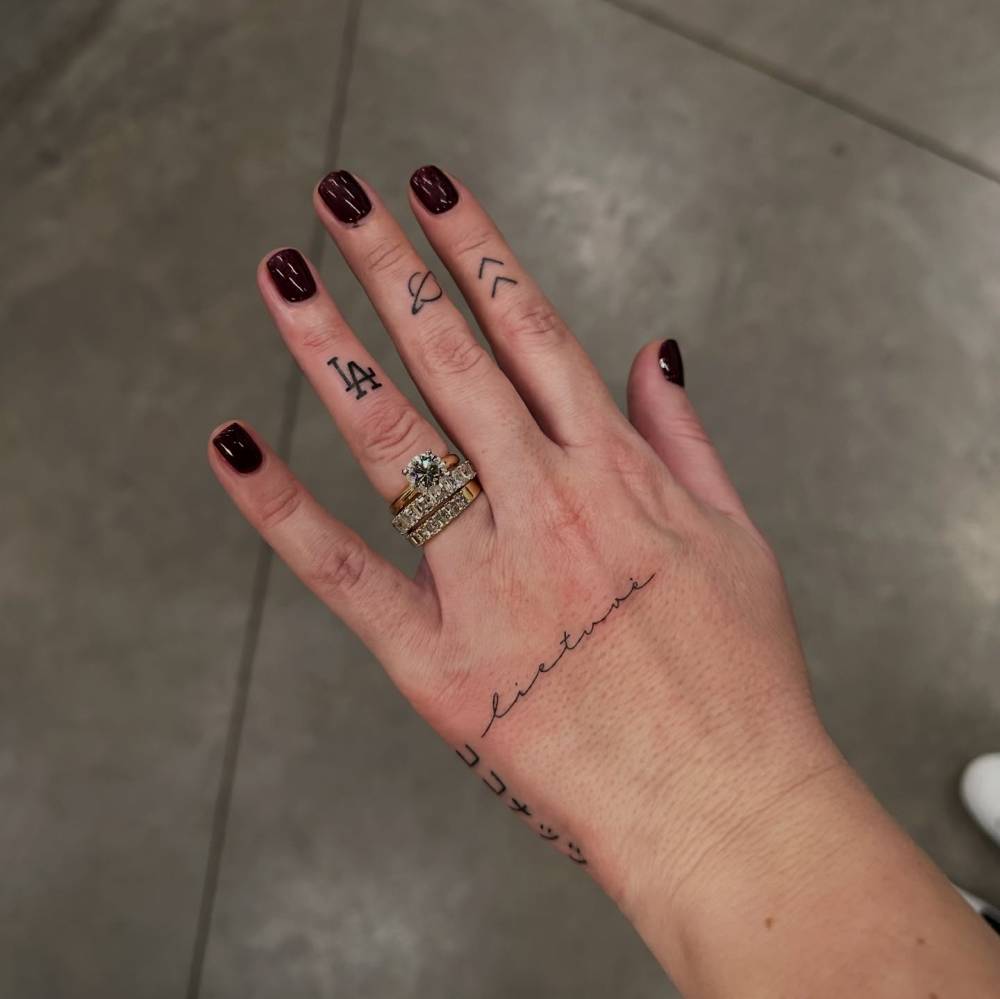 "Lietuvė" lettering tattoo done in handwritten font.