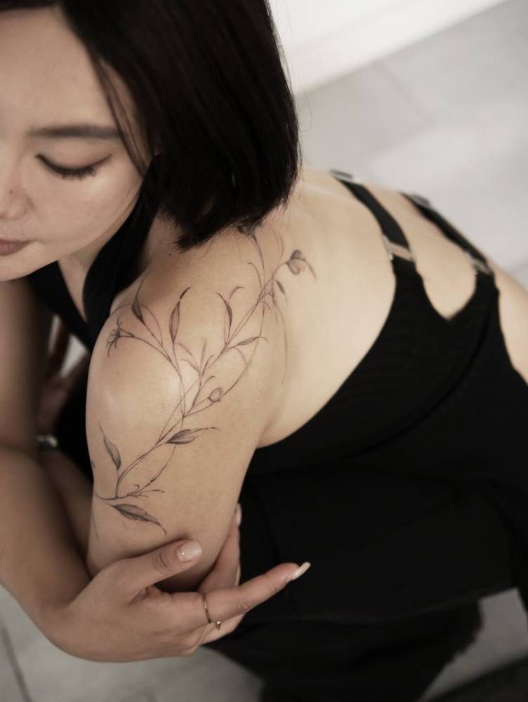 Leaves tattoo in illustrative style placed on the shoulder.
