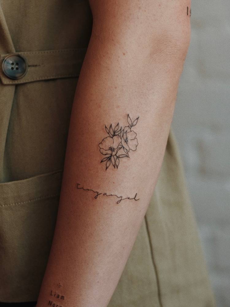 "Tiny angel" and poppy flowers tattoo located on the forearm.