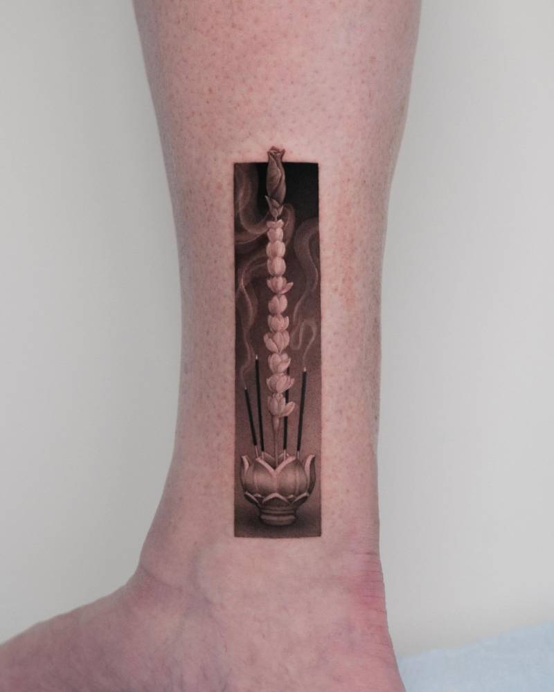 Incense tattoo located on the ankle, micro-realistic style.