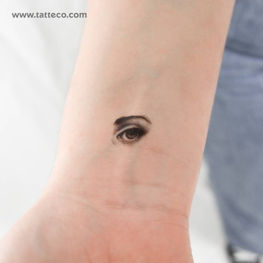 Little eye and eyebrow temporary tattoo located on the wrist.