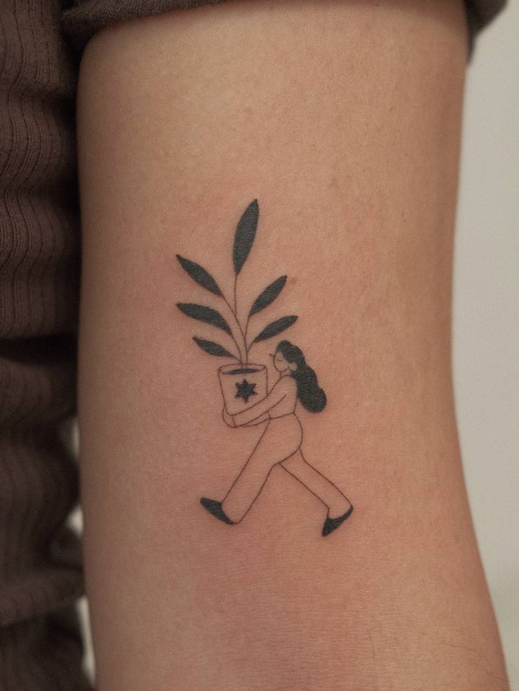 Woman carrying a plant pot tattooed on the bicep.