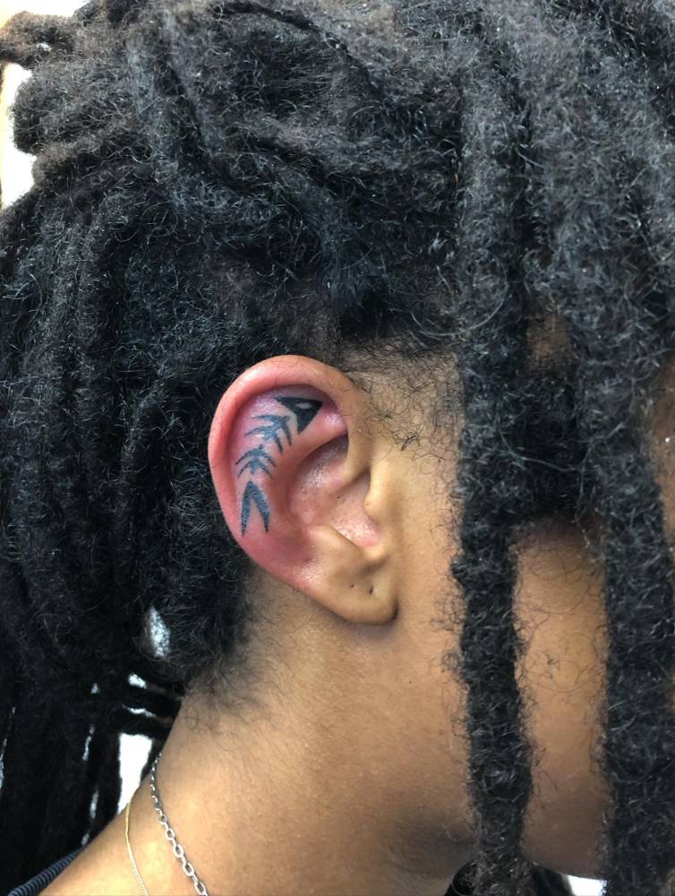 Hand poked fish skeleton tattoo located on the ear.
