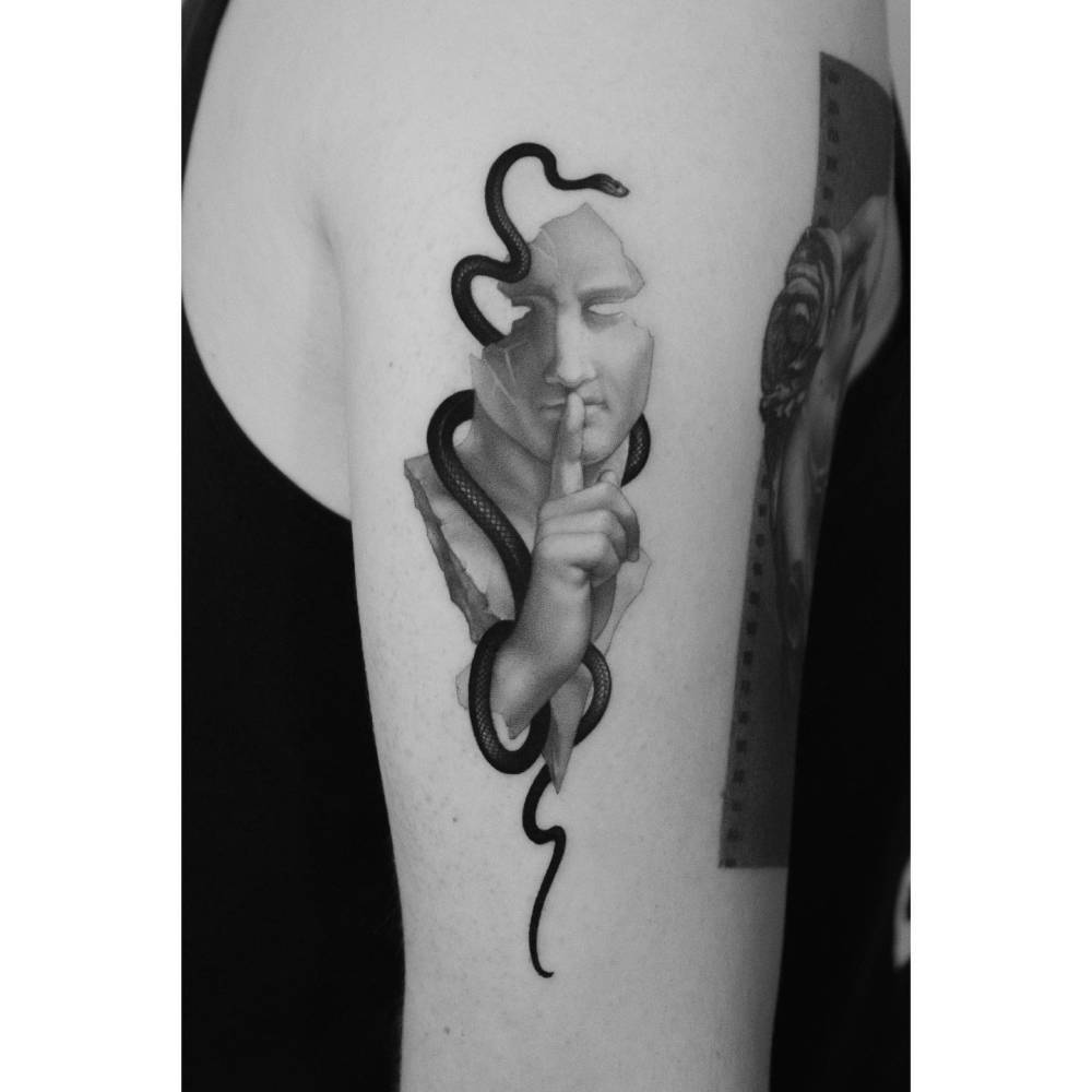 Snake and sculpture tattoo in micro-realistic style located on the upper arm.