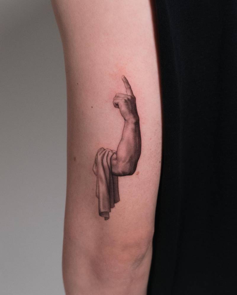 Micro-realistic style Socrates' hand tattoo located on the tricep.