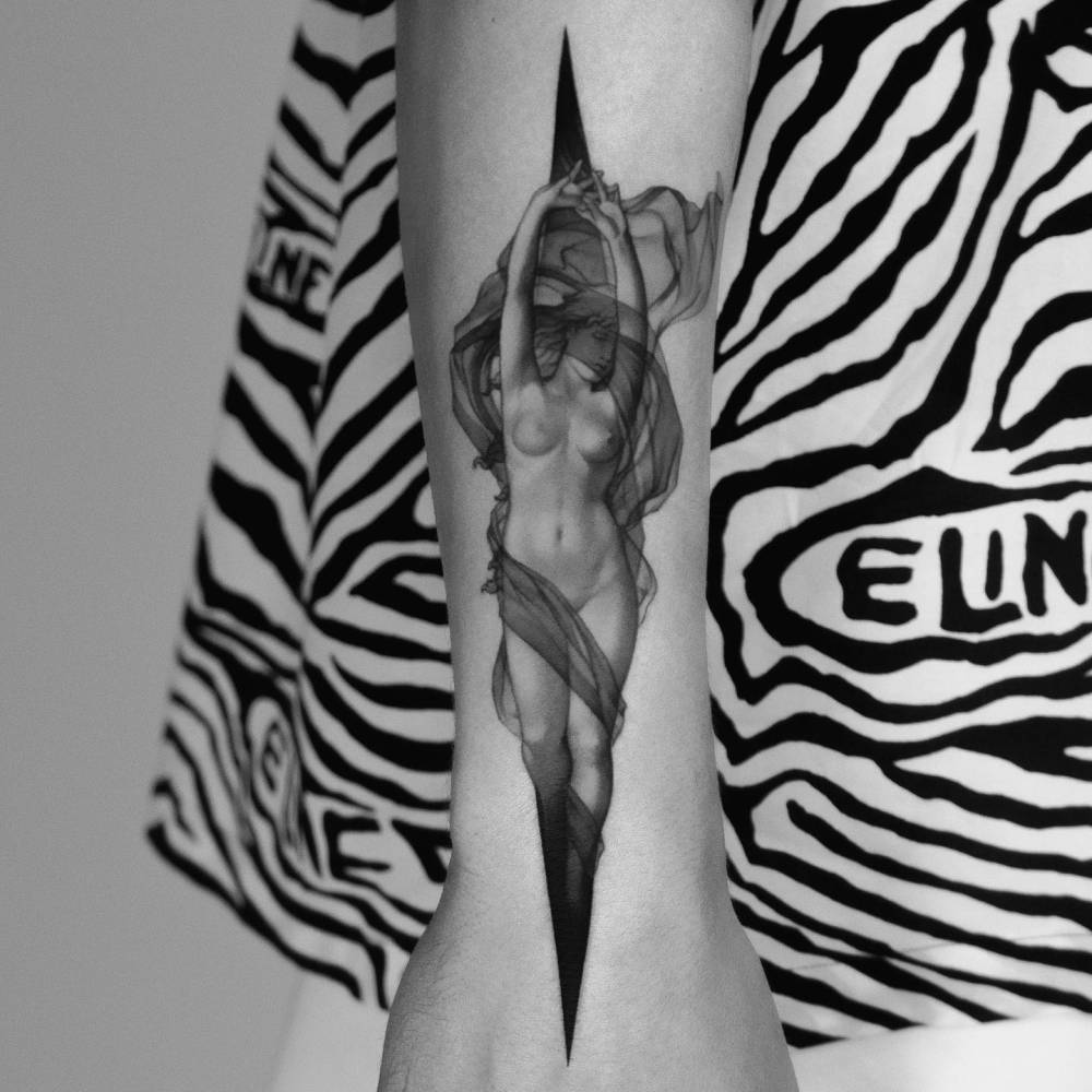 Nude woman tattoo in micro-realistic style located on the wrist.