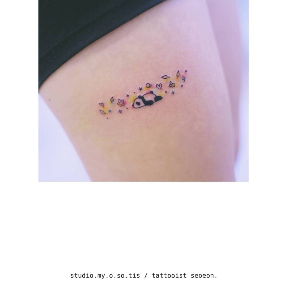 Little panda tattoo located on the thigh, cartoon style.