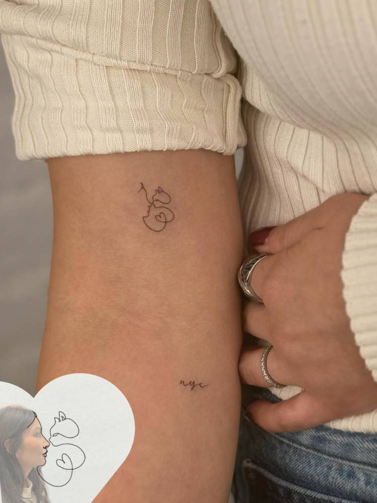 Cat kiss tattoo located on the bicep.