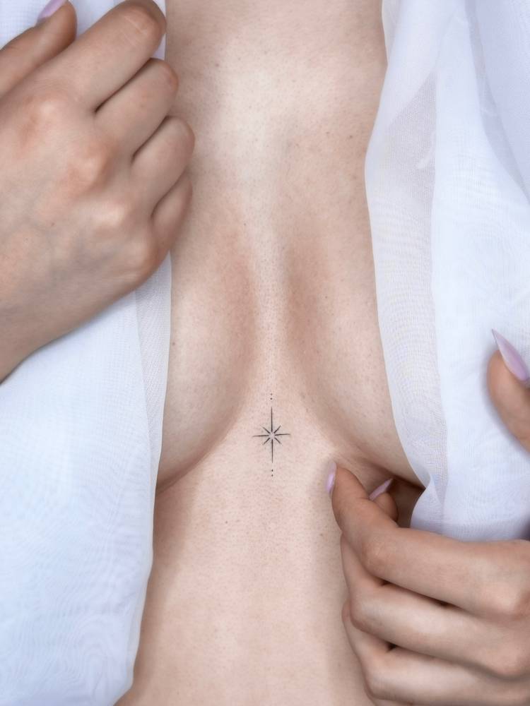 North star tattoo in minimalistic style placed on the sternum.