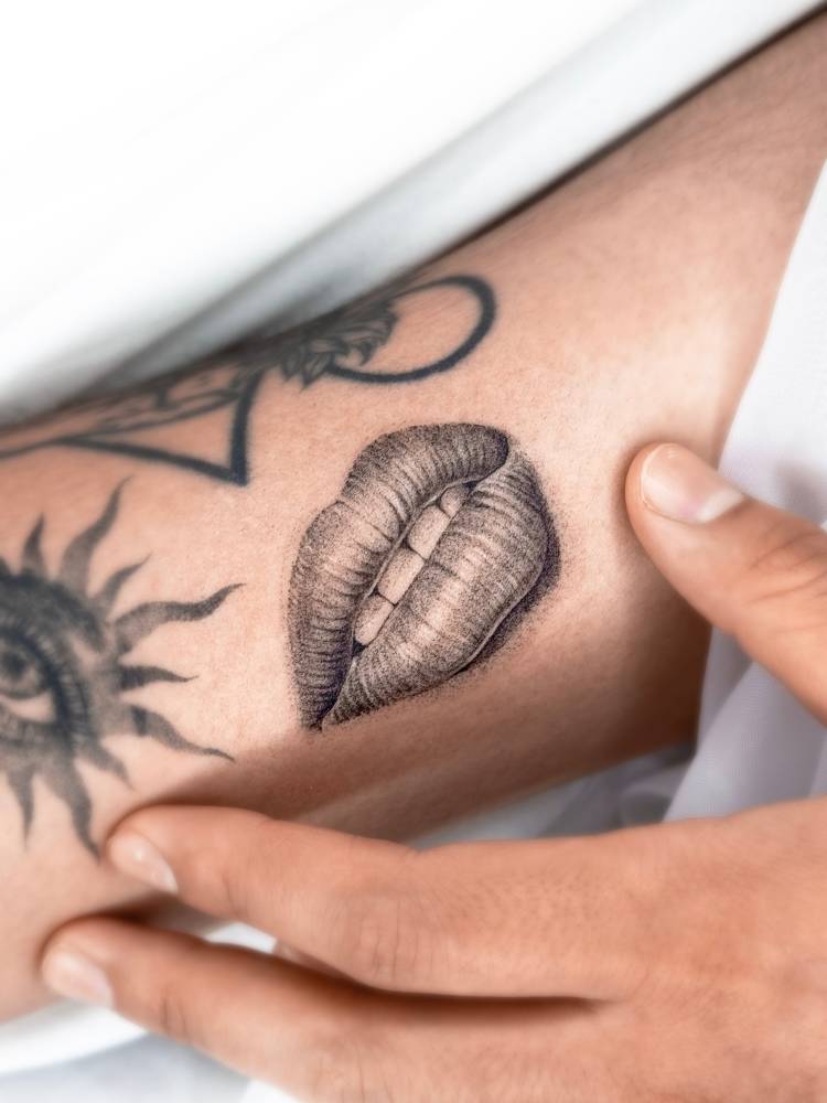 Mouth tattoo located on the inner arm, micro-realistic style.