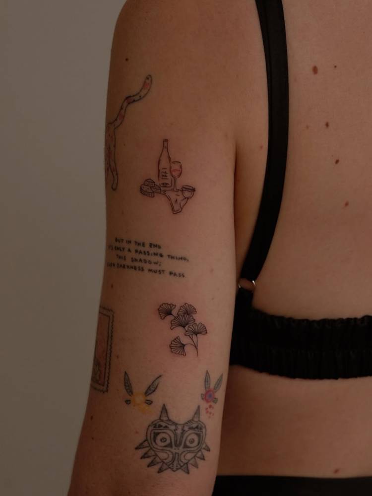Wine bottle and ginkgo leaves tattoo located on the tricep.