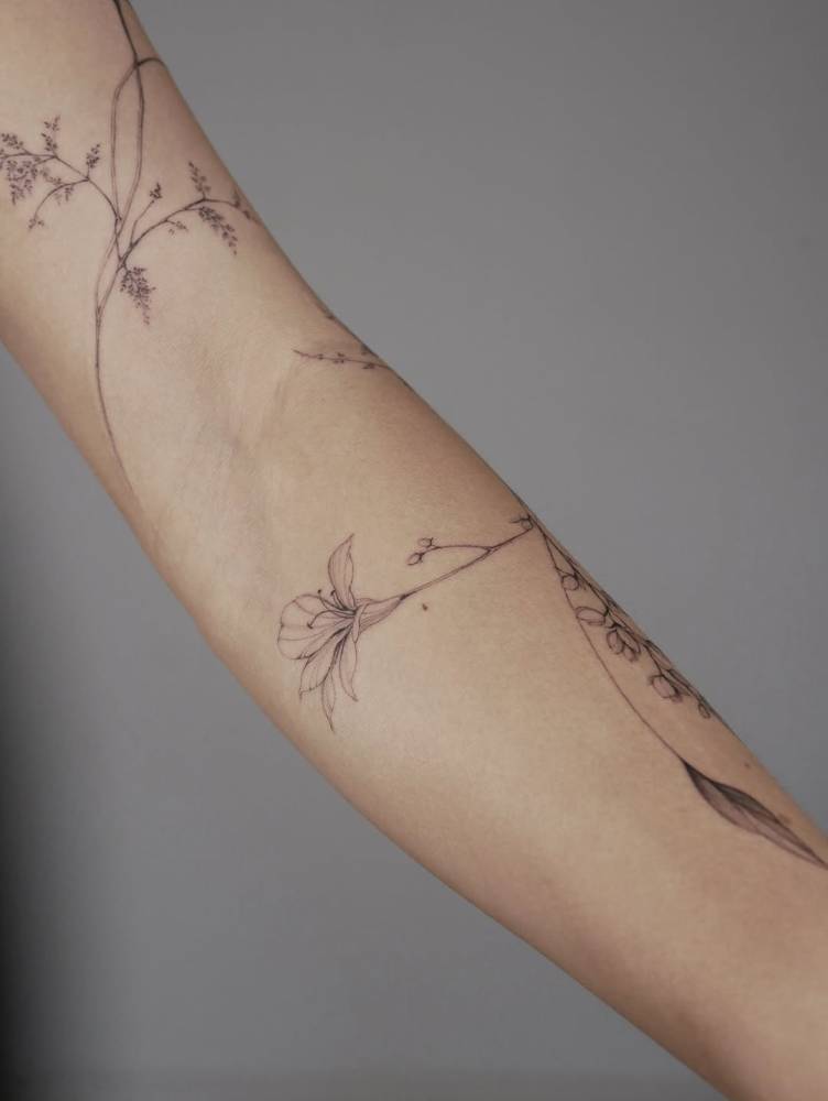 Lily flower tattoo located on the inner forearm.