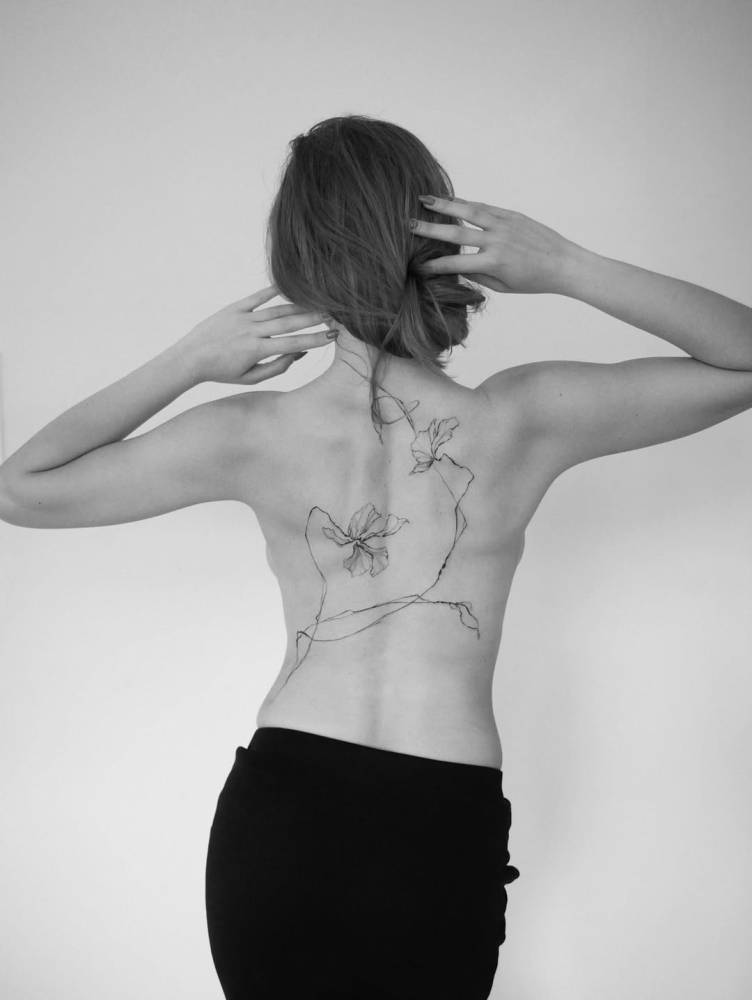 Floral design tattooed on the back, illustrative style.