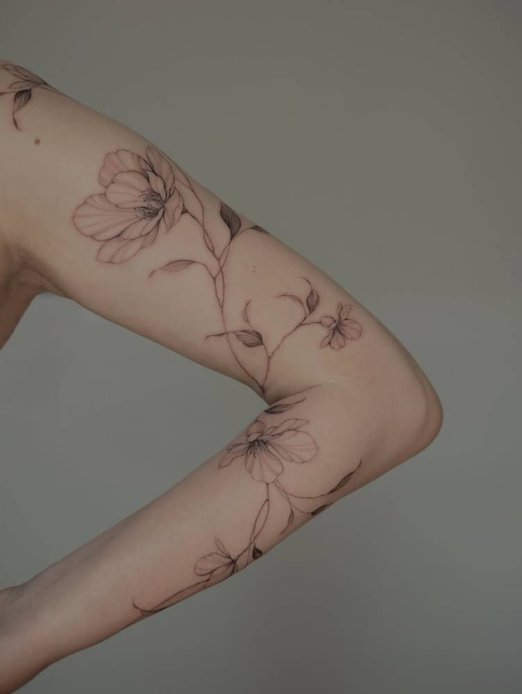 Flowers tattoo in illustrative style done on the arm.