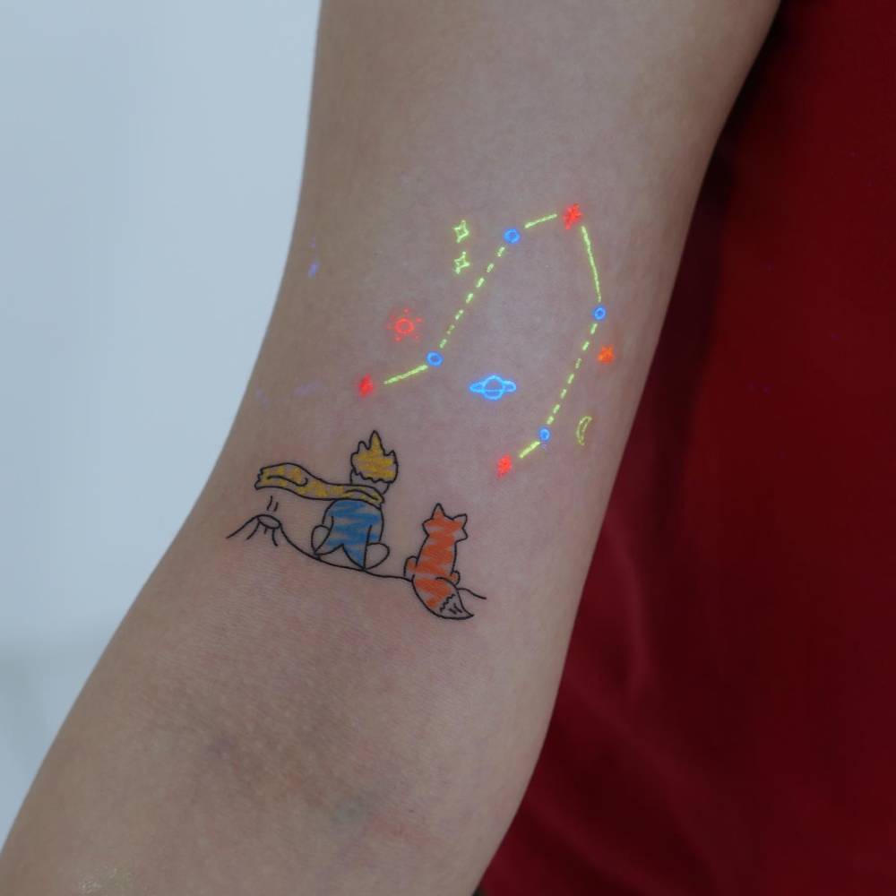 The Little Prince tattoo in cartoon style located on the bicep.