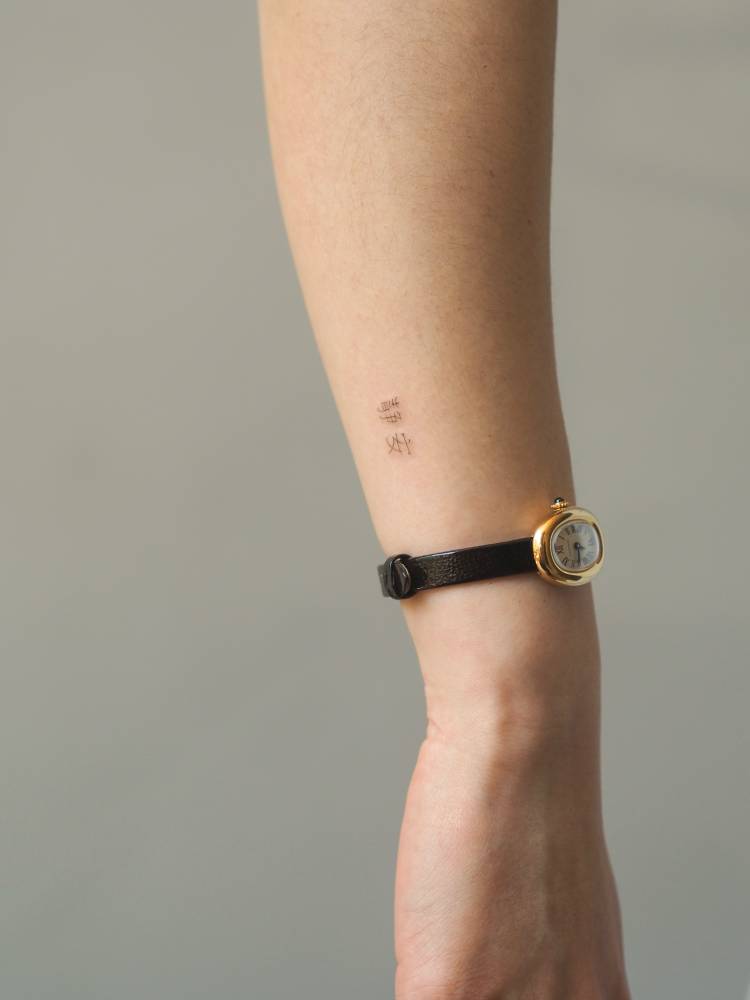 Chinese lettering tattoo located on the wrist.