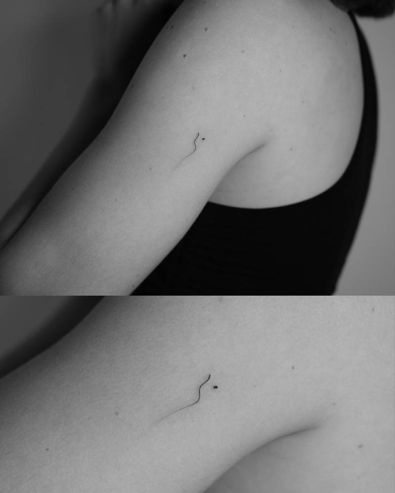 Abstract design tattooed on the tricep, minimalistic style.
