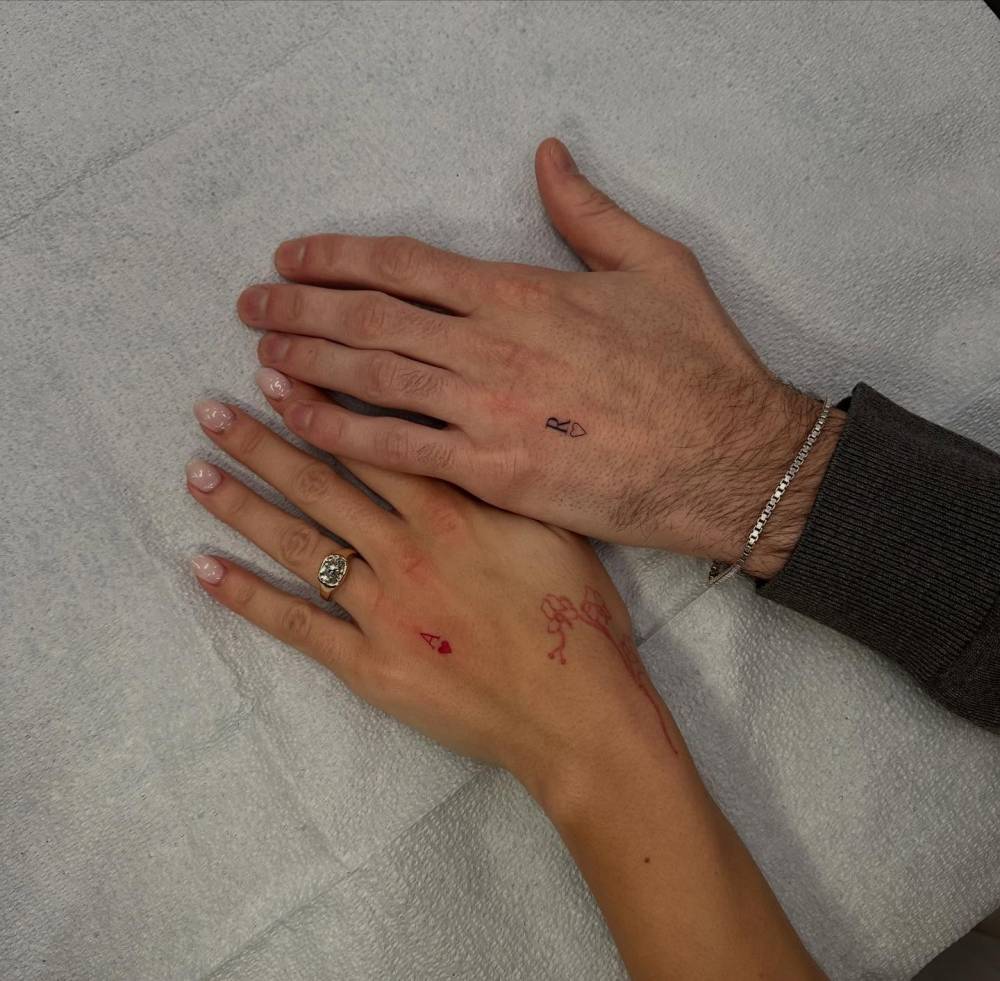 Matching initials and heart tattoo for couple.