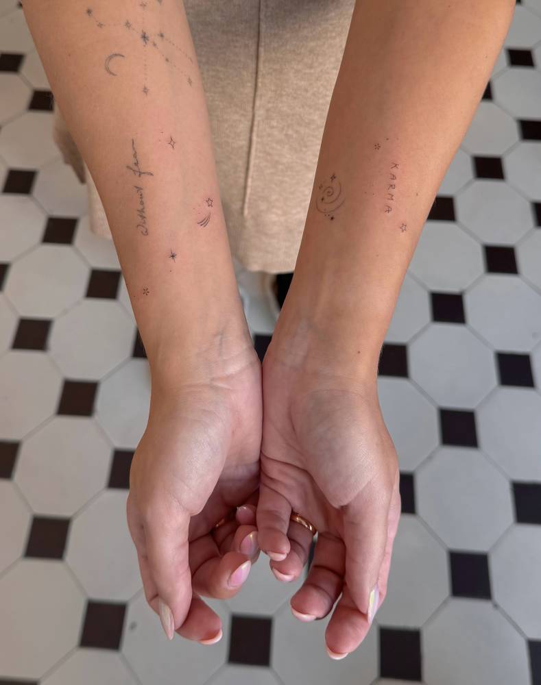 Sparkling stars tattoo located on the inner forearms.