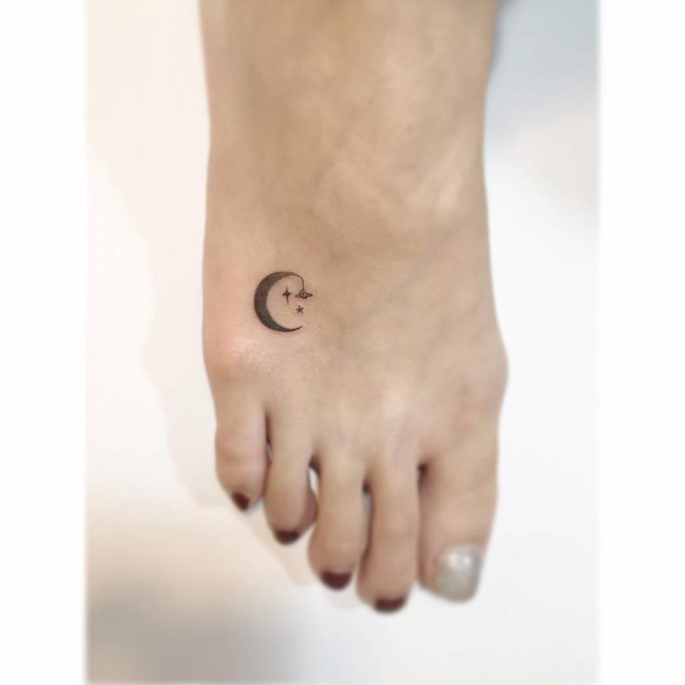 Crescent moon and stars tattoo located on the foot.