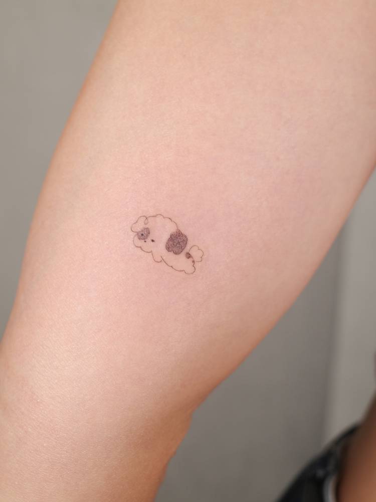 Cute little dog tattoo in cartoon style located on the inner arm.