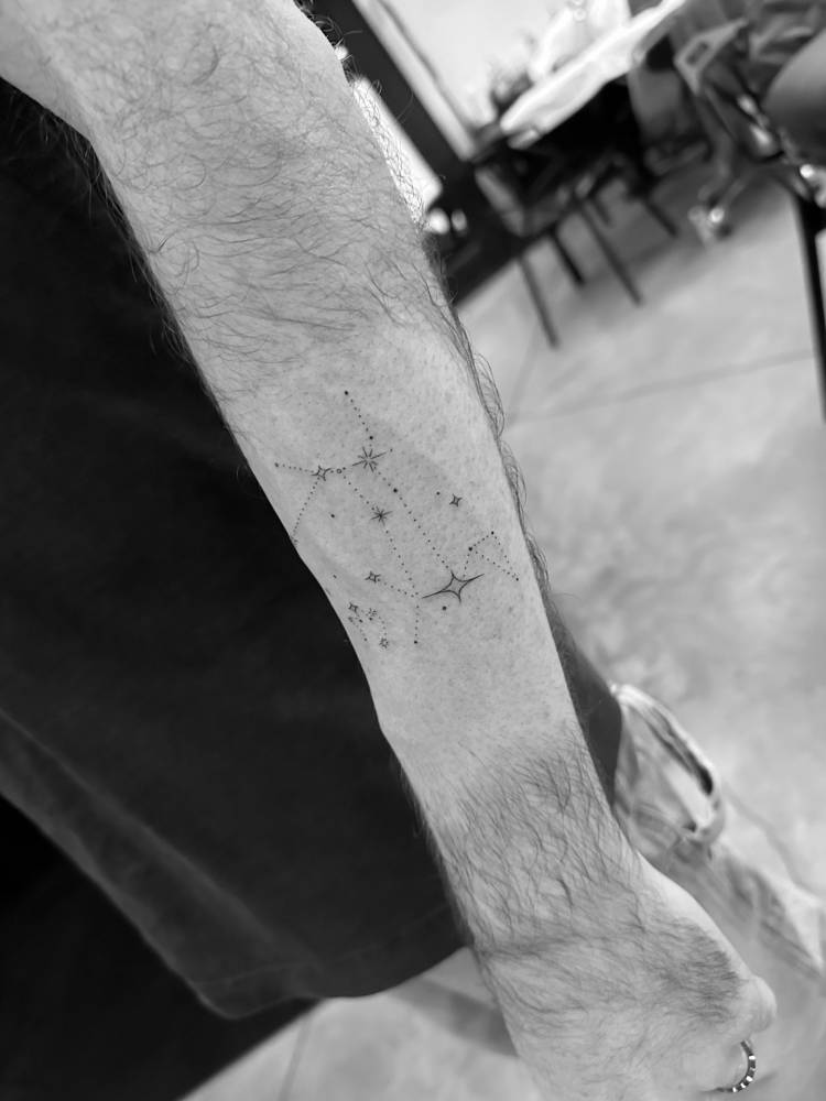 Constellation tattoo located on the forearm, minimalist style.