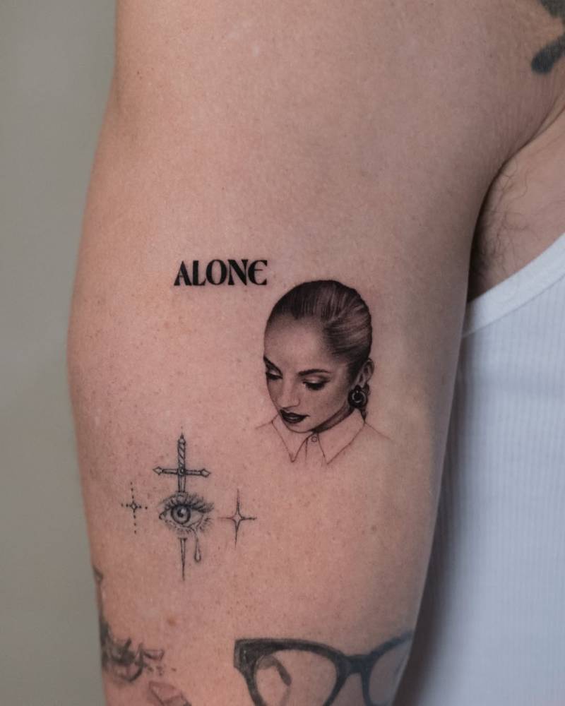 Sade portrait tattoo in micro-realistic style located on the upper arm.