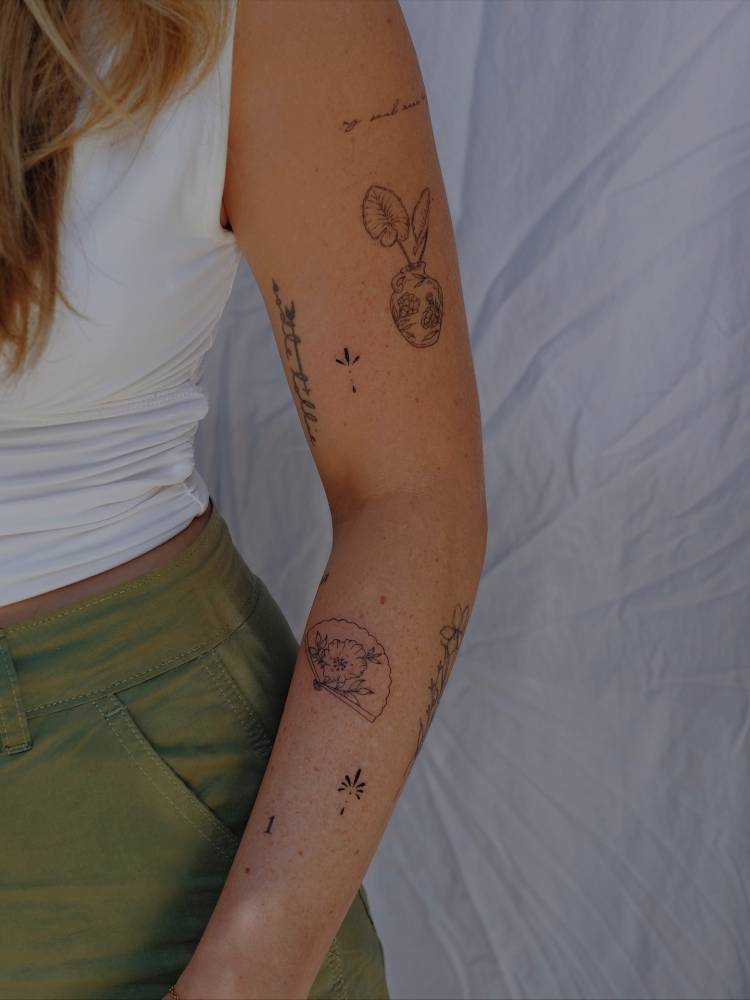 Arm composition tattoos in fine line style.