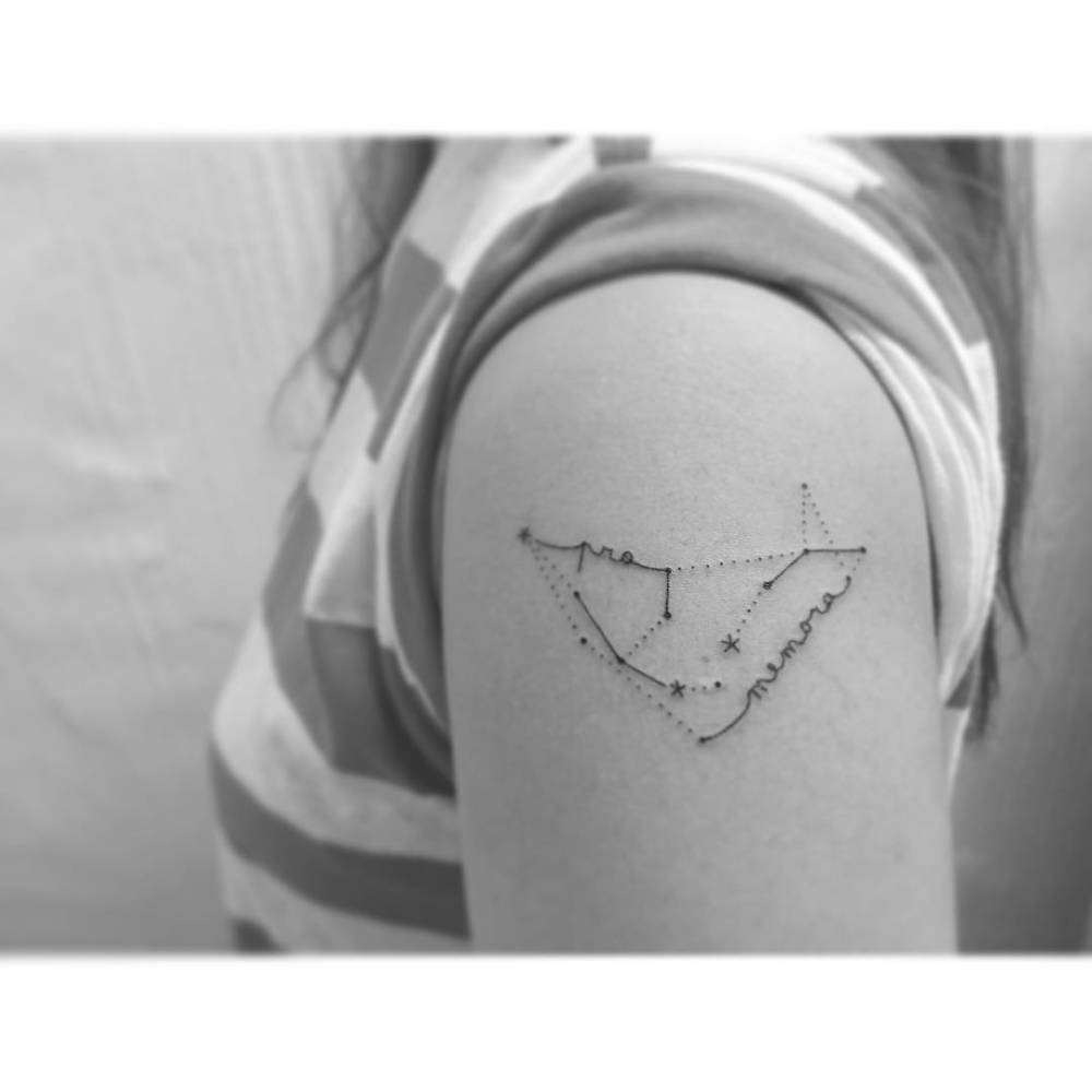 Capricornus and Aquarius constellations tattooed on the upper arm.