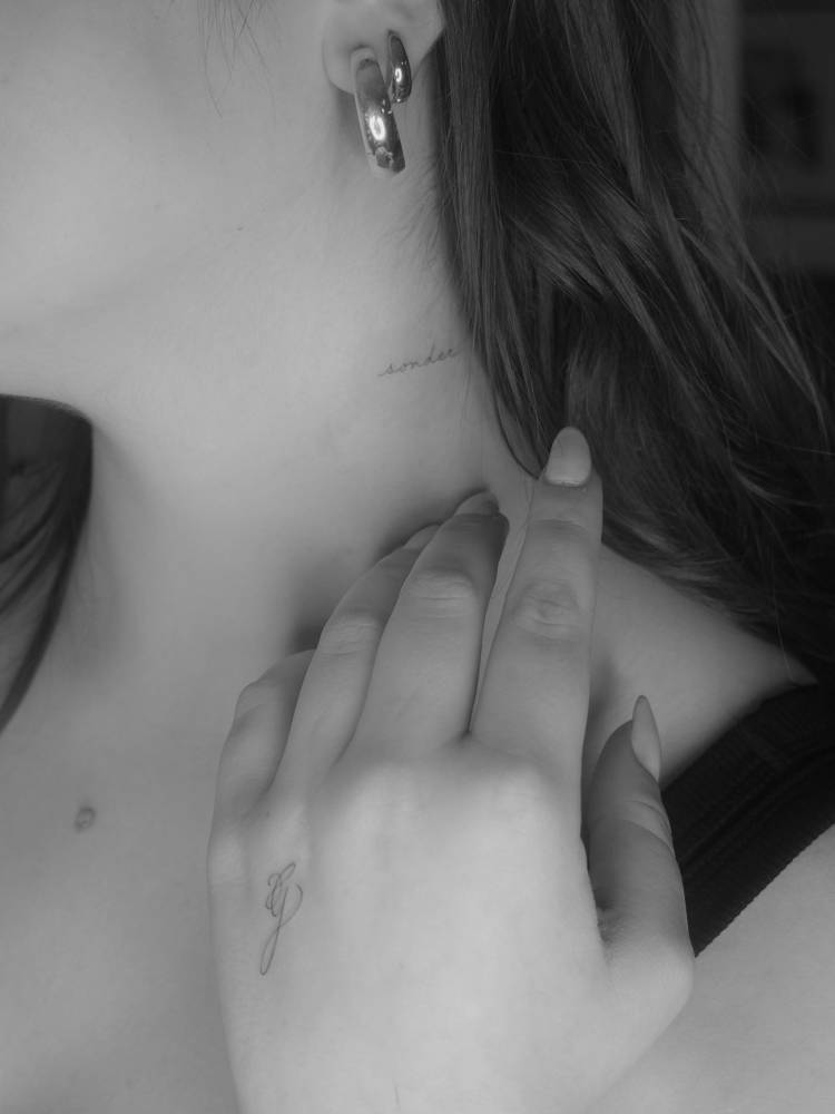 Script font letter "G" tattoo placed on the hand.