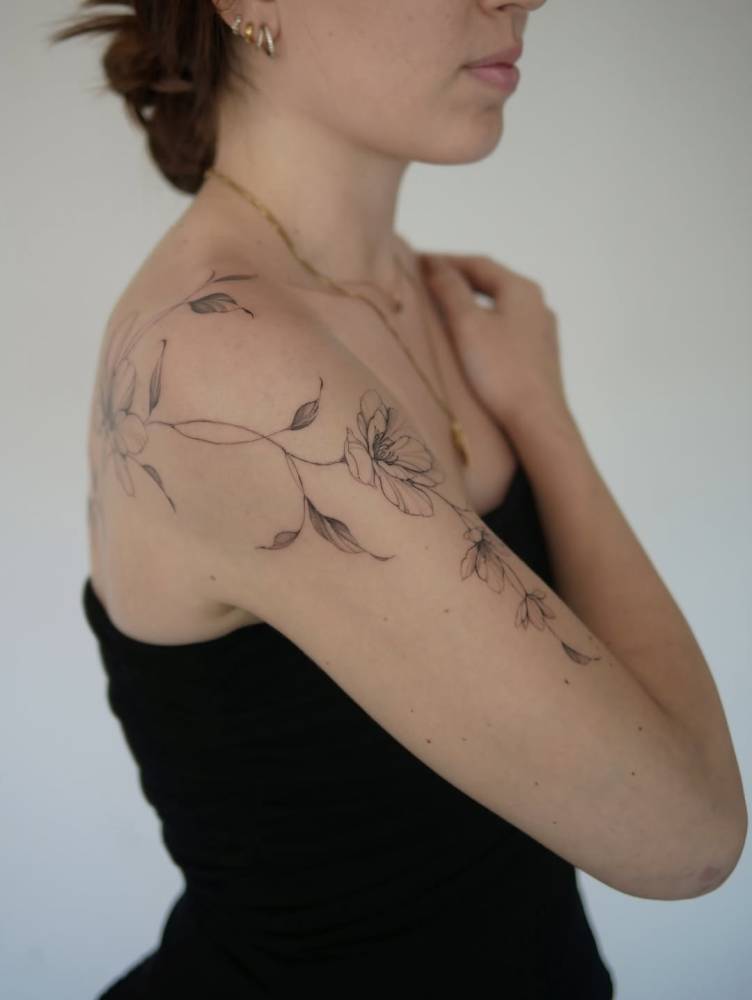 Flowers tattoo located on the upper arm and shoulder.