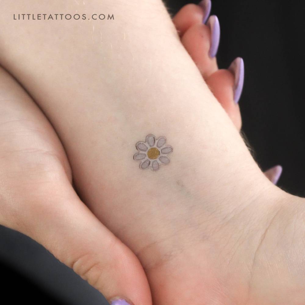 Silver enamel daisy temporary tattoo located on the wrist.