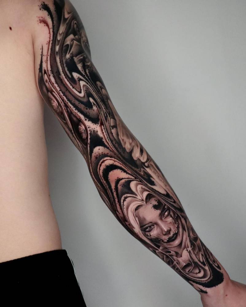 Harley Quinn portrait sleeve tattoo in black and grey style.