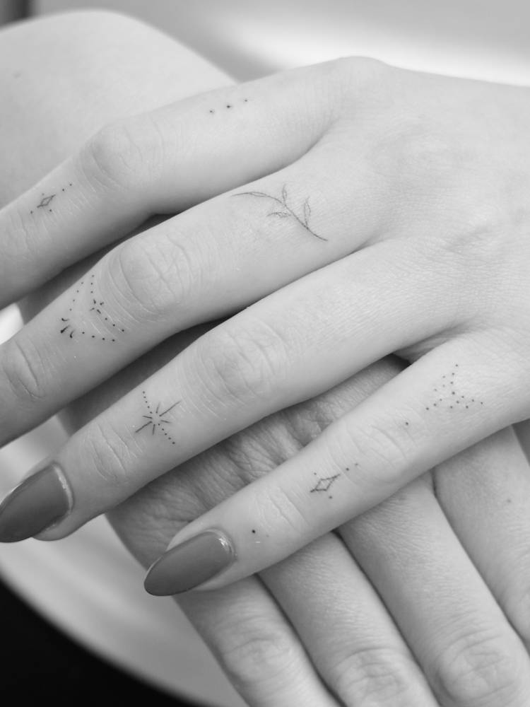 Tiny ornamental finger composition tattoos.