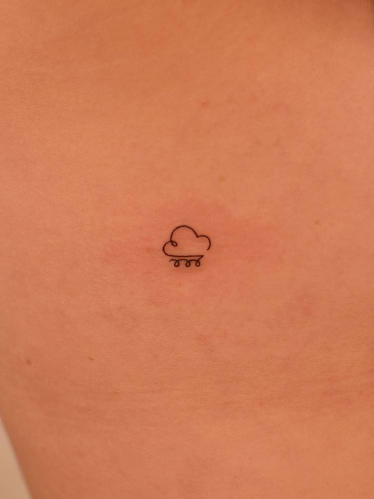Minimalist style rain tattoo located on the rib.