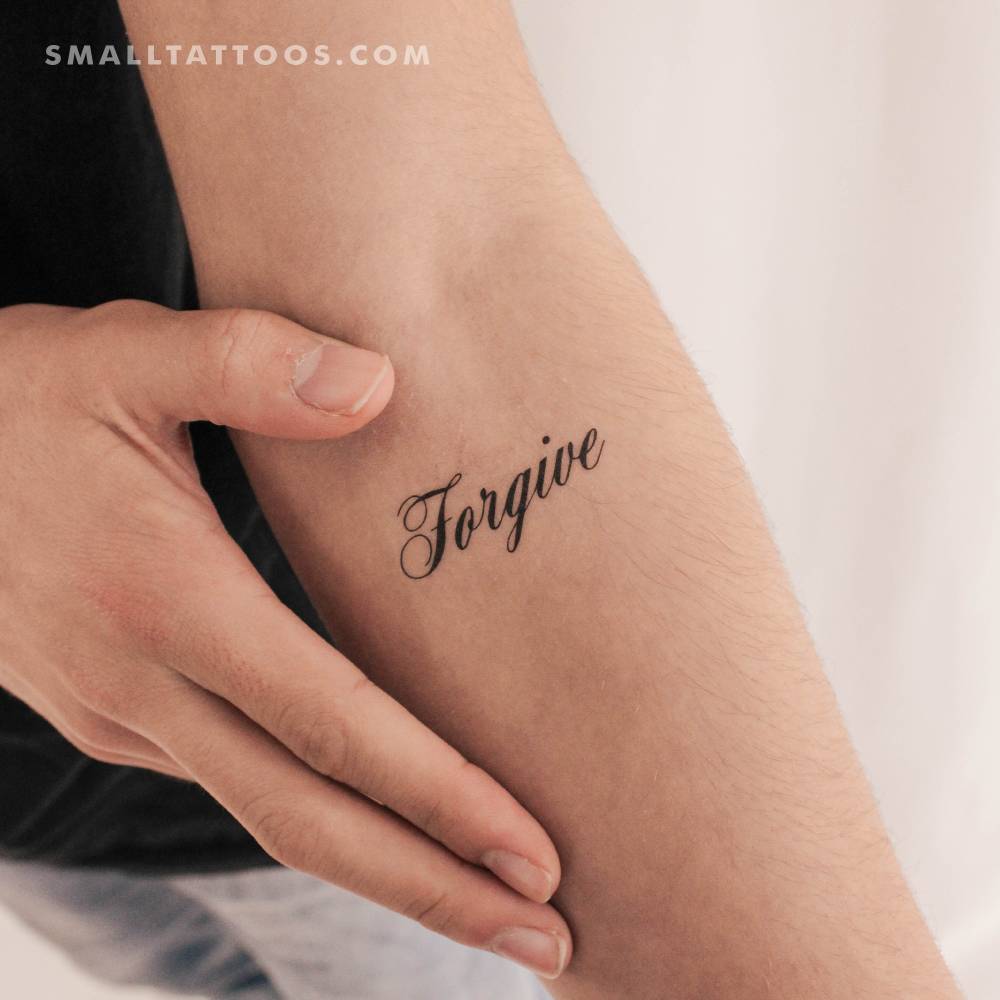 Script font word "forgive" temporary tattoo located on the inner forearm.