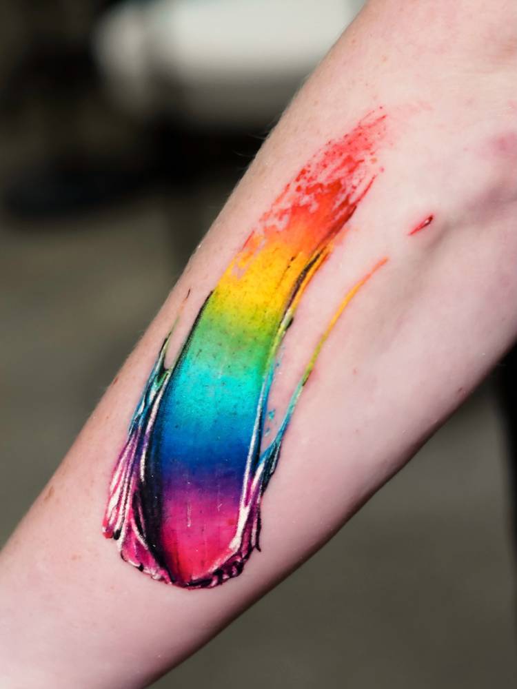 Visible spectrum brush stroke tattoo in realistic style.
