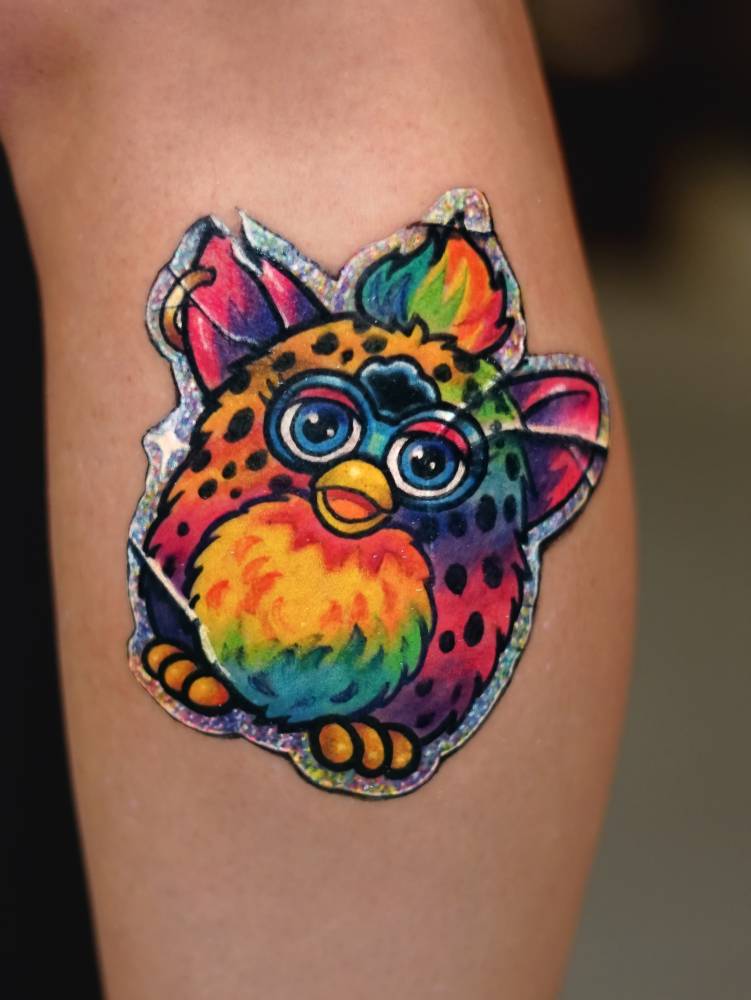 Furby sticker tattoo in cartoon style located on the calf.