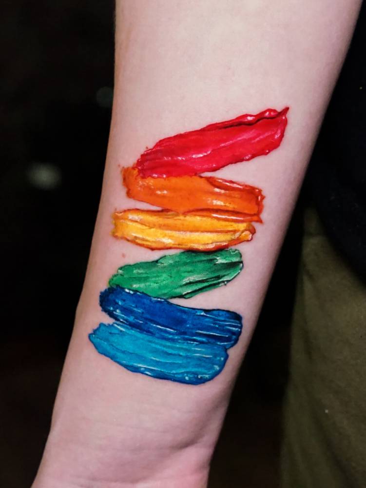 Visible spectrum brush strokes tattooed on the wrist.