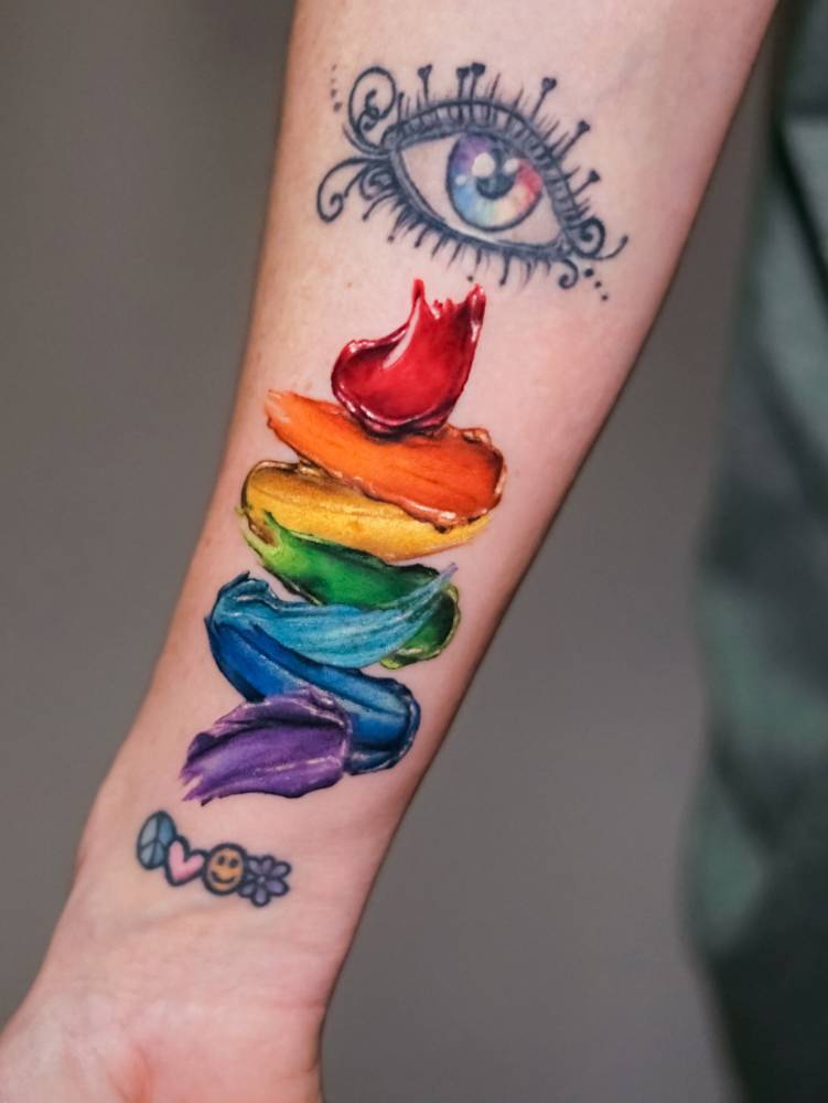 Brush strokes visible spectrum tattoo located on the wrist.