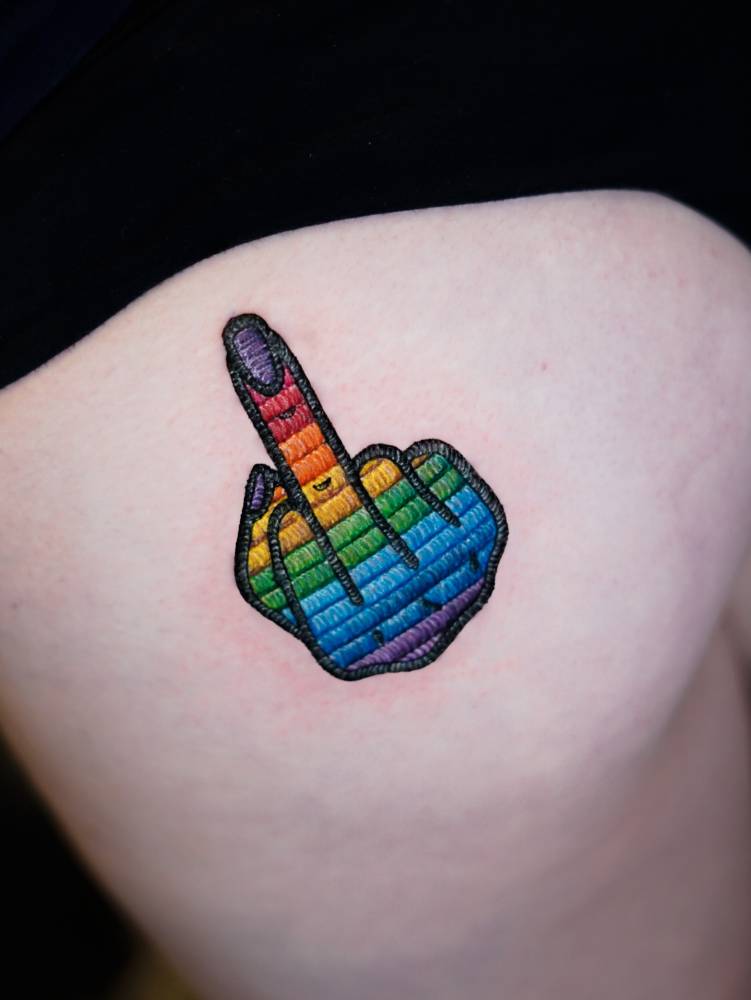 The finger patch tattoo located on the butt cheek, embroidery style.