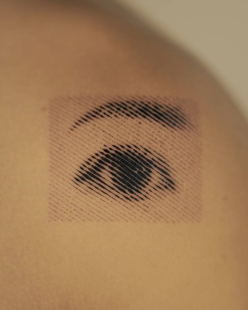 Halftone eye tattoo located on the shoulder.