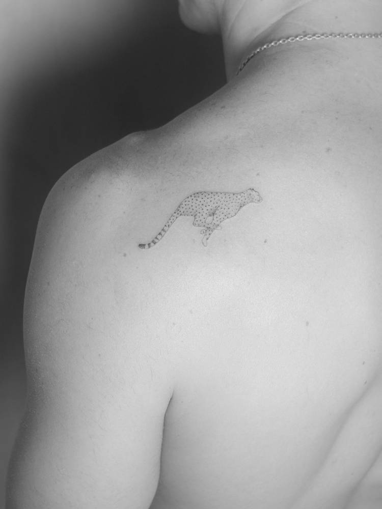 Cheetah tattoo in illustrative style located on the shoulder blade.